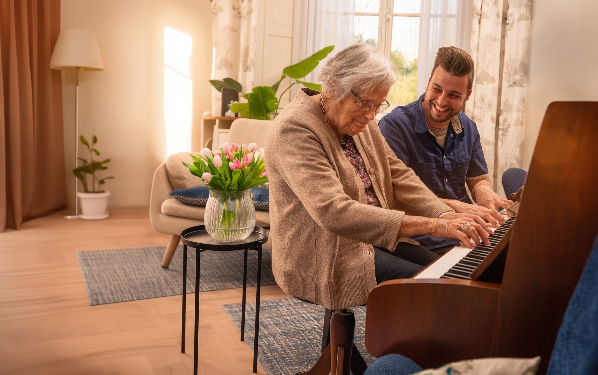 Bewoner speelt piano samen met medewerker